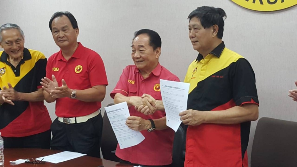 PBK president Voon Lee Shan (right) and PSB president Datuk Seri Wong Soon Koh exchange the MoU documents after the signing ceremony. — Picture courtesy of Priscilla Lau