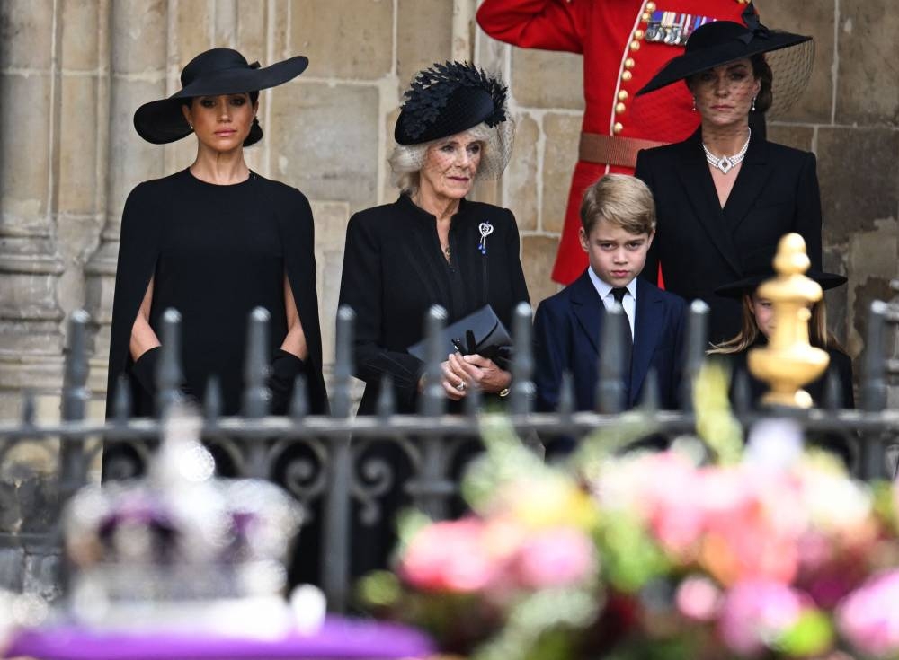 (From left) Meghan, Duchess of Sussex, Camilla, Queen Consort, Prince George of Wales and Catherine, Princess of Wales look at the coffin of Queen Elizabeth II, draped in a Royal Standard and adorned with the Imperial State Crown and the Sovereign’s orb and sceptre, as they leave Westminster Abbey in London on September 19, 2022, after the State Funeral Service for Britain’s Queen Elizabeth II. — Oli Scarff/Pool/AFP pic
