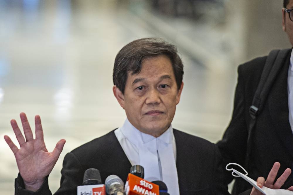 Lawyer Hisyam Teh Poh Teik speaks to the media at the Palace of Justice in Putrajaya August 23, 2022. — Picture by Shafwan Zaidon