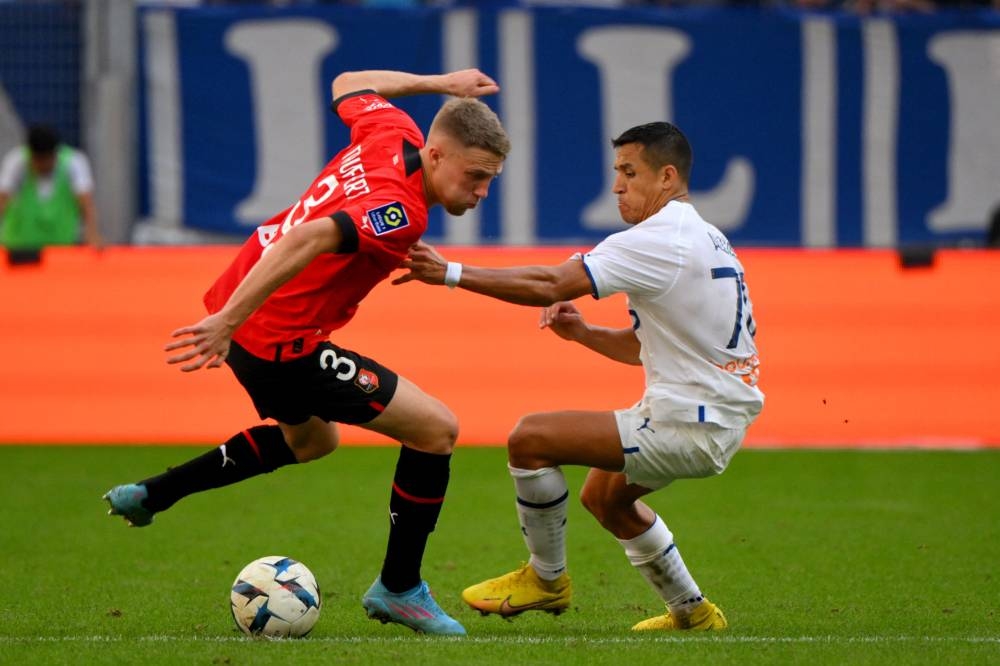 Rennes defender Adrien Truffert (left) fights for the ball with Marseille forward Alexis Sanchez during the French L1 match between Olympique Marseille (OM) and Stade Rennais FC (Rennes) at Stade Velodrome in Marseille, southern France, September 18, 2022. — AFP pic 