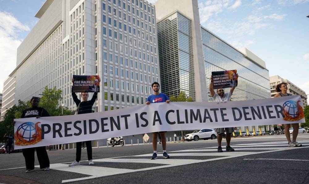 Climate activists hold a banner in front of the World Bank Headquarters calling out its President David Malpass after he appeared to express doubt about the origins and trajectory of climate change, in Washington September 22, 2022. — Reuters pic 
