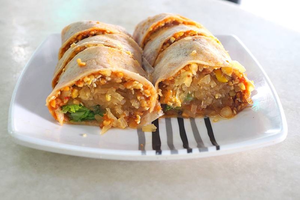 You get stewed yam bean, crunchy dough bits, peanuts, omelette and cabbage leaves in the 'popiah'.
