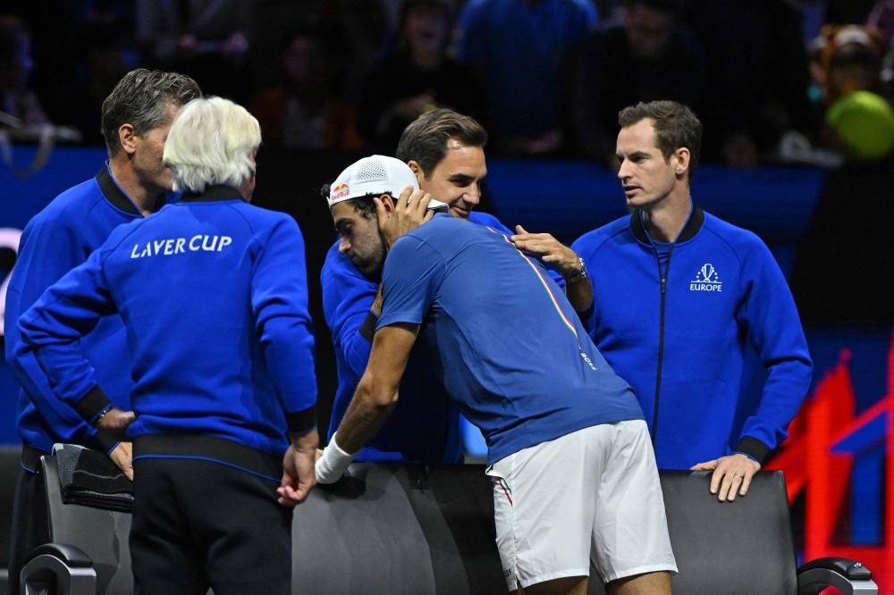 Italy’s Matteo Berrettini (centre) of Team Europe is congratulated by Switzerland’s Roger Federer after his win over Canada’s Felix Auger-Aliassime of Team World in their 2022 Laver Cup men’s singles tennis match at the O2 Arena in London on September 24, 2022. ― AFP pic