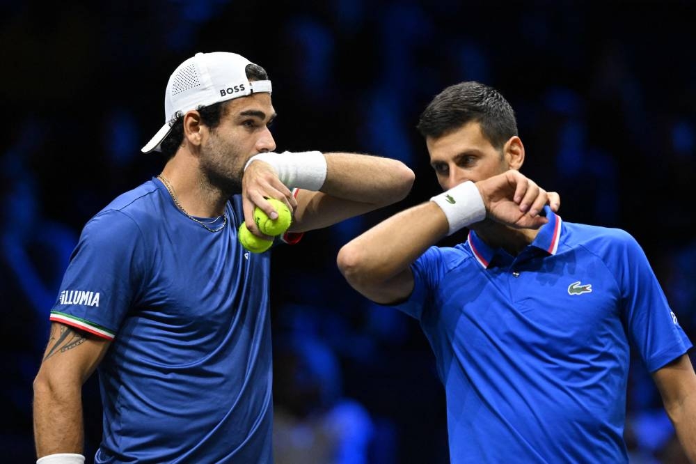 Matteo Berrettini communicates with Novak Djokovic for Team Europe as they play against Jack Sock and Alex De Minaur of Team World during their 2022 Laver Cup men's doubles tennis match at the O2 Arena in London on September 24, 2022. — AFP pic