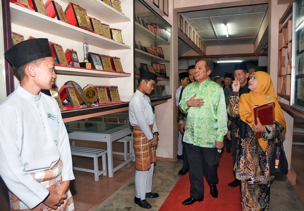 Abang Johari (2nd right) is being briefed by Zainab on the achievements of the school when touring the gallery. — Penerangan pic via Borneo Post