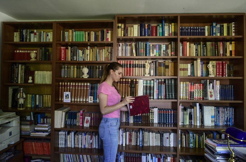 A visitor looks through a volume in the library of Stevo Stepanovski in the village of Babino in western Macedonia. — AFP pic