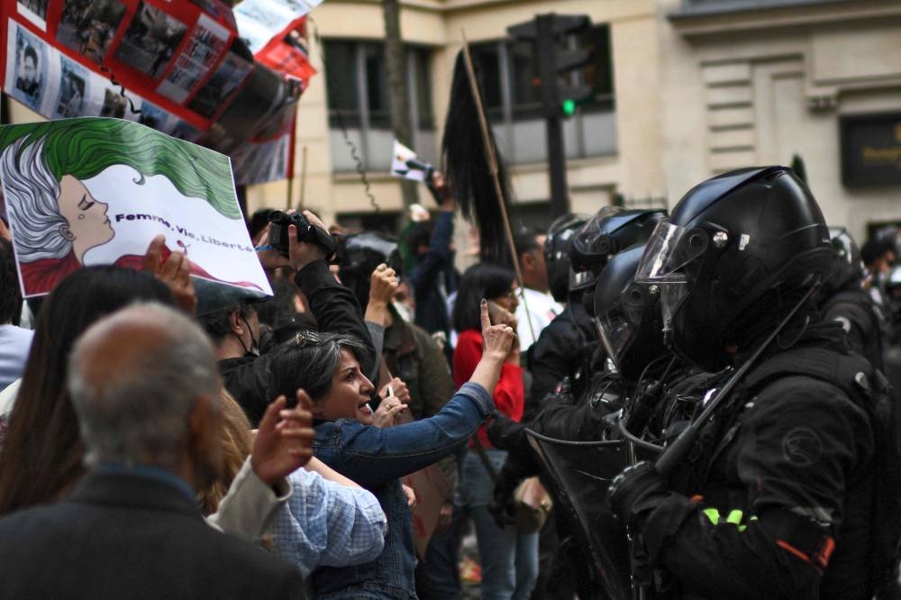 People face riot police as they take part in a demonstration in support of Iranian protesters in Paris, on September 25, 2022. — AFP pic