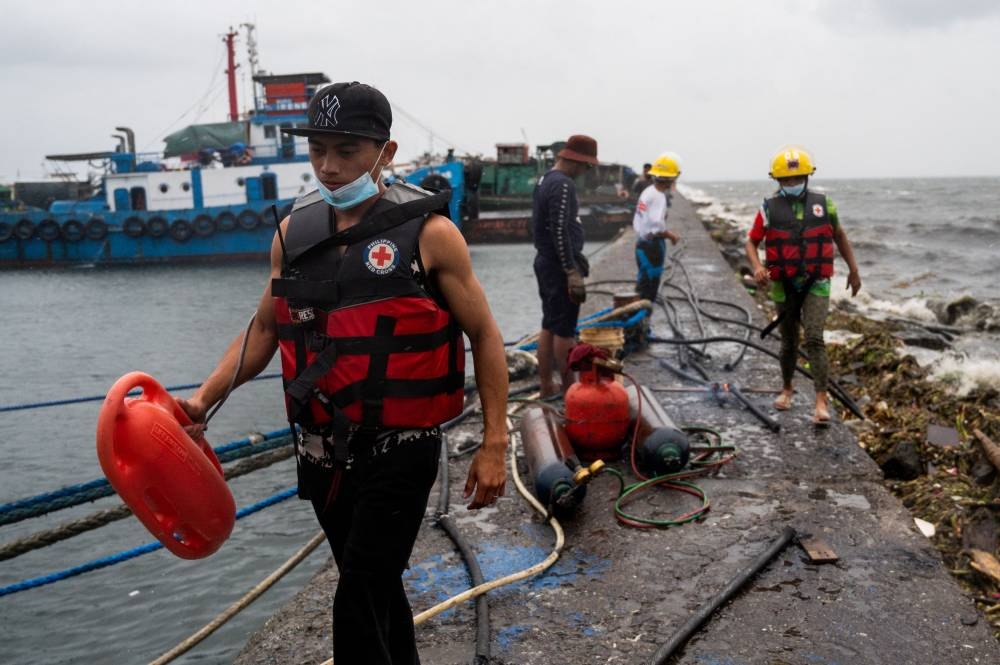 Volunteers and local officials patrol the neighbourhood to remind residents to evacuate, in preparation for Super Typhoon Noru, in Manila, Philippines, September 25, 2022. — Reuters pic