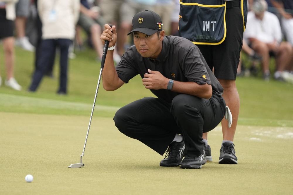 Hideki Matsuyama lines up his putt on the first green during the singles match play of the Presidents Cup golf tournament at the Quail Hollow Club in Charlotte September 25, 2022. — Reuters pic