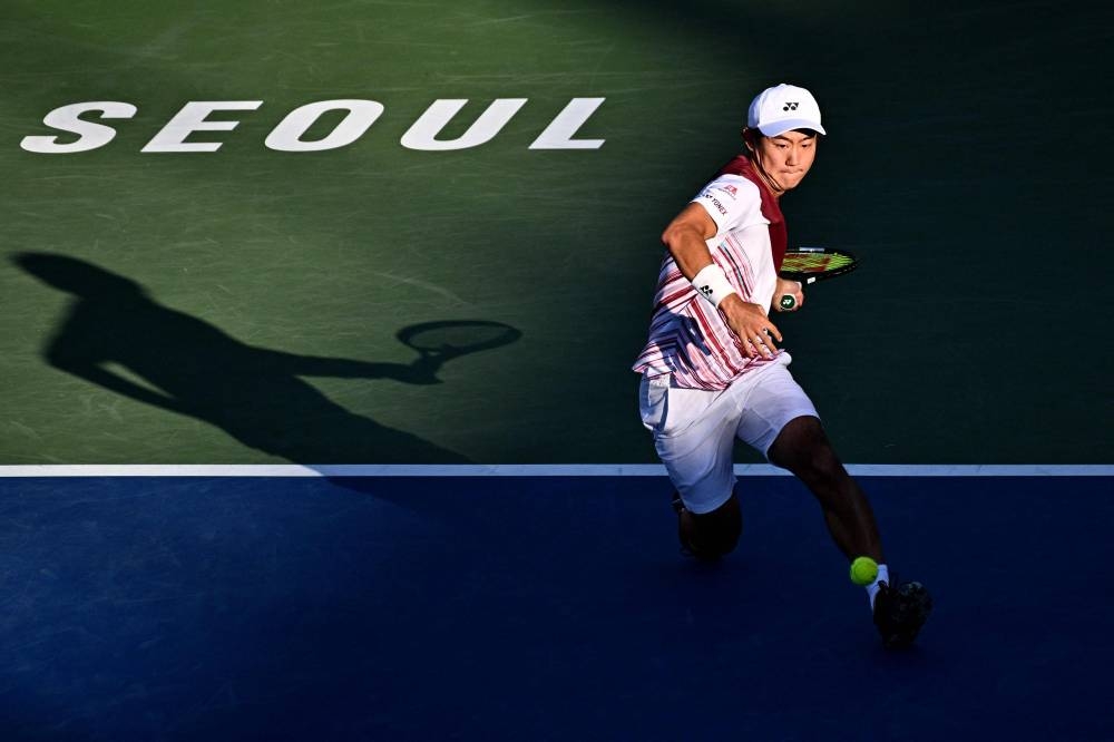 Yoshihito Nishioka of Japan hits a return against Daniel Evans of Britain during their men’s singles match at the Korea Open Tennis Championships in Seoul, September 27, 2022. — AFP pic 