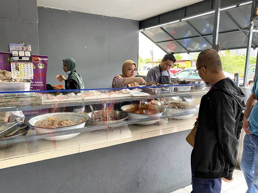 Behind the counter, they will pack your food choices with rice or glutinous rice.