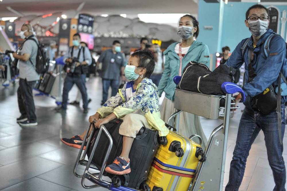 File picture of tourists wearing face masks at KLIA 2, January 27, 2020. The Health Ministry today said that face masks were optional aboard planes effective immediately. — Picture by Shafwan Zaidon