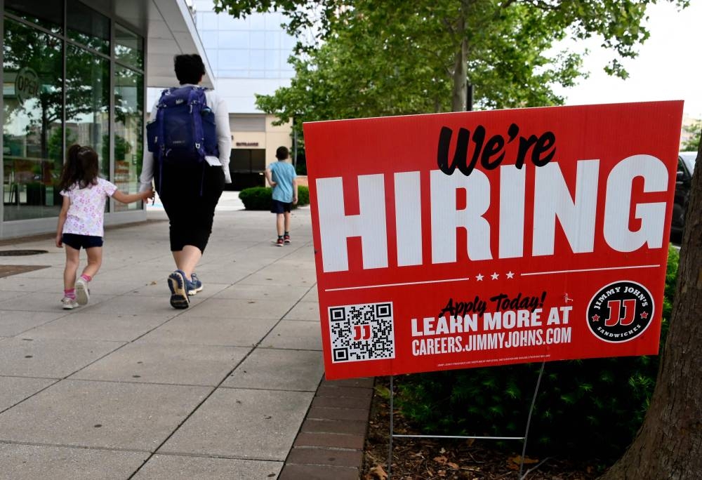 In this file photo taken on June 3, 2022, people walk past a ‘now hiring’ sign posted outside of a restaurant in Arlington, Virginia. — AFP pic