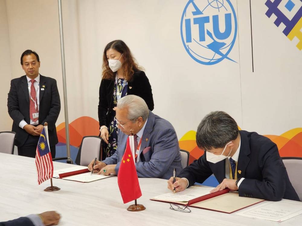 Communications and Multimedia Minister Tan Sri Annuar Musa and China’s Deputy Minister of Industry and Information Technology, Zhang Yunming sign the MoU in Bucharest, Romania, September 28, 2022. — Picture from Twitter/Bernama 