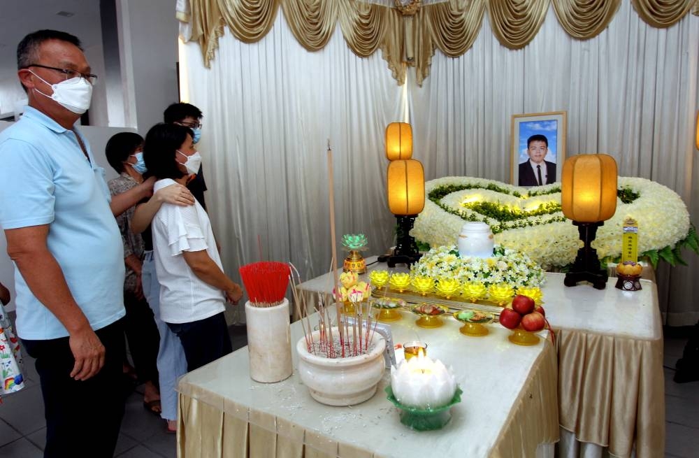 The ashes of Goi Zhen Feng, who is believed to be a victim of a job fraud syndicate and died on May 11 in Thailand, were brought home to his residence in Ipoh, September 16, 2022. The victim’s father Chee Kong, 50, (left) and mother with two sons and a daughter and relatives could not contain their sadness during a special prayer ceremony before the ashes were buried. — Bernama pic