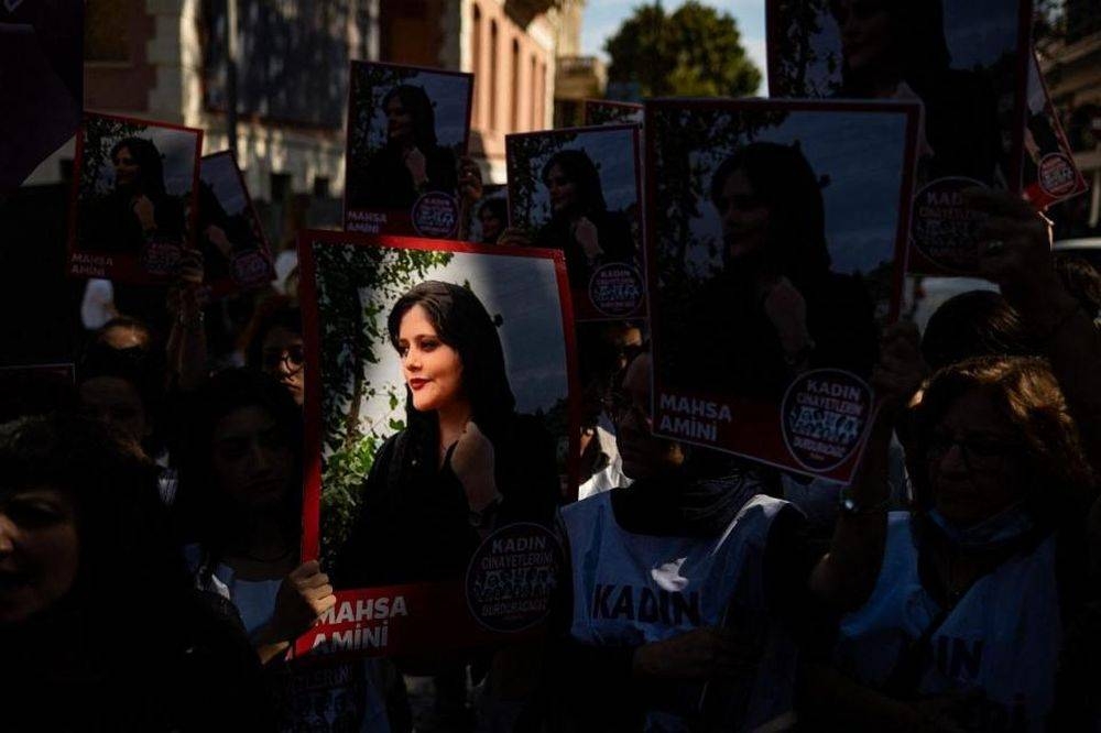 Protestors hold banners with the portrait of Iranian Mahsa Amini. — AFP pic