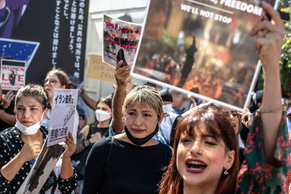 People chant slogans during the ‘Freedom rally for Iran’ event in Shibuya district of Tokyo on October 1, 2022.. ― AFP pic