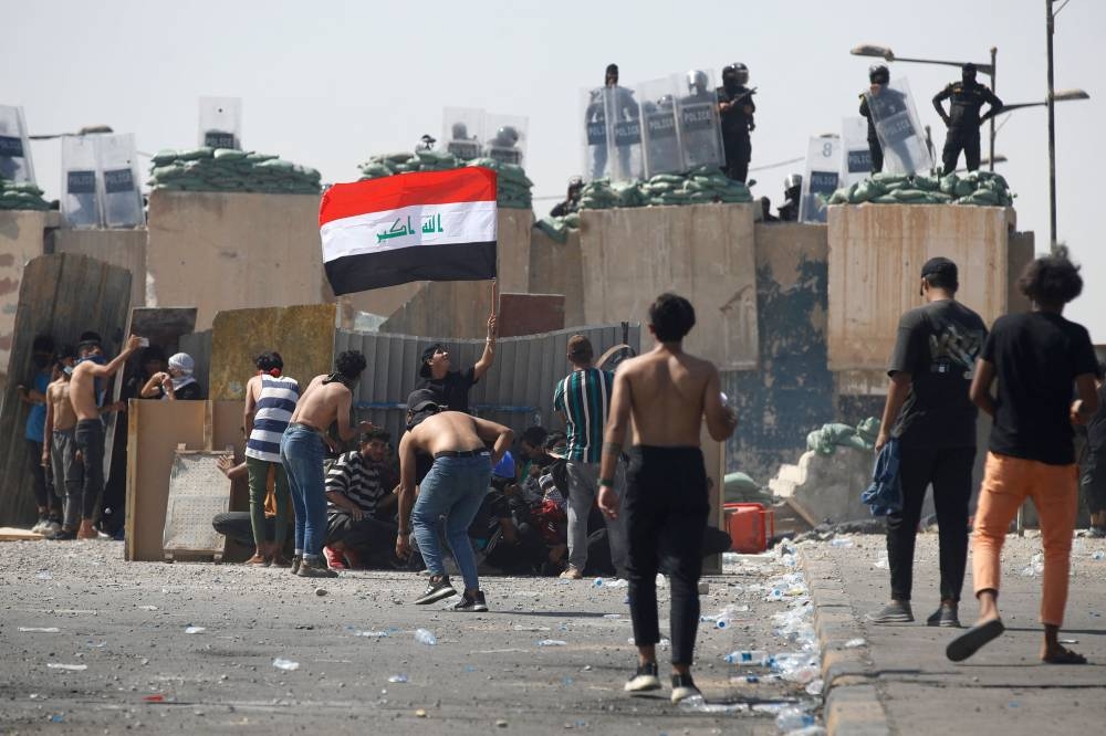 Iraqi anti-government demonstrators clash with security forces during a protest on the Jumhuriya (Republic) bridge leading to the capital Baghdad’s high-security Green Zone on October 1, 2022. ― AFP pic