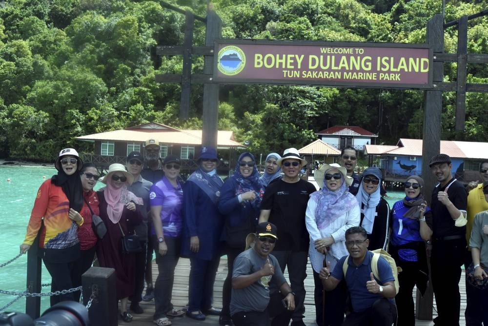 Malaysian Communications and Multimedia Ministry (K-KOMM) Secretary-General Datuk Seri Mohammad Mentek (sixth right) posing for a commemorative photo with his entourage upon arriving at Tun Sakaran Marine Park on Bohey Dulang Island for a visit, October 1, 2022. — Bernama pic