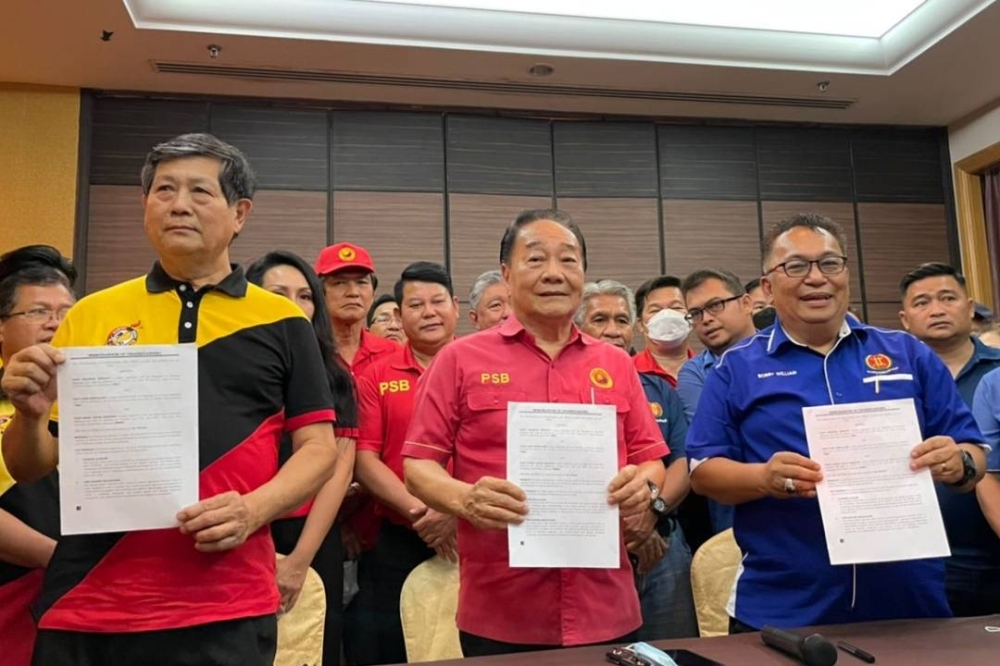 (From left) Voon, Wong and Bobby show the signed MoU documents. — Borneo Post pic