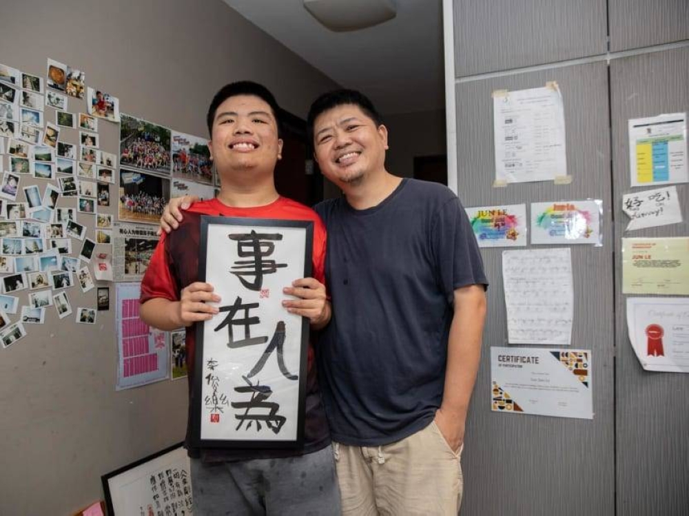 Mr Bob Lee Keng Siang (right) and his son Jun Le with his artwork on Sept 20, 2022. — TODAY pic