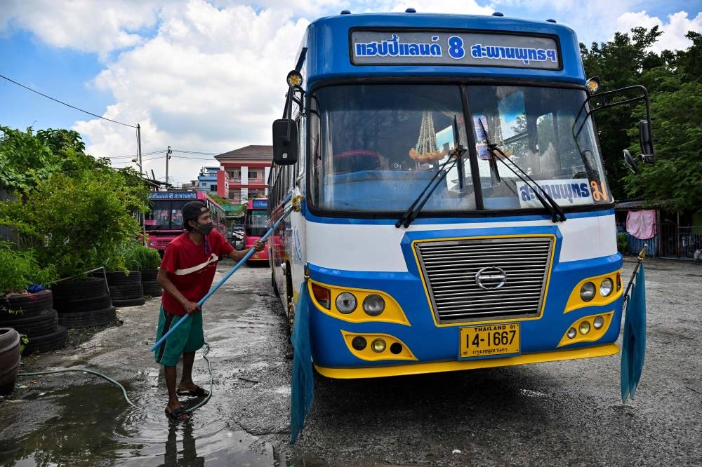 This photo taken on August 27, 2022 shows bus driver Aphisak “Boy” Sodmui cleaning the No. 8 bus on his day off at the bus garage in Bangkok. — AFP pic