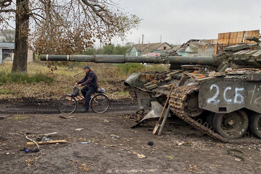 A local resident rides a bicycle past an abandoned Russian tank in the village of Kurylivka, amid Russia's attack on Ukraine, in Kharkiv region, Ukraine October 1, 2022. — Reuters pic