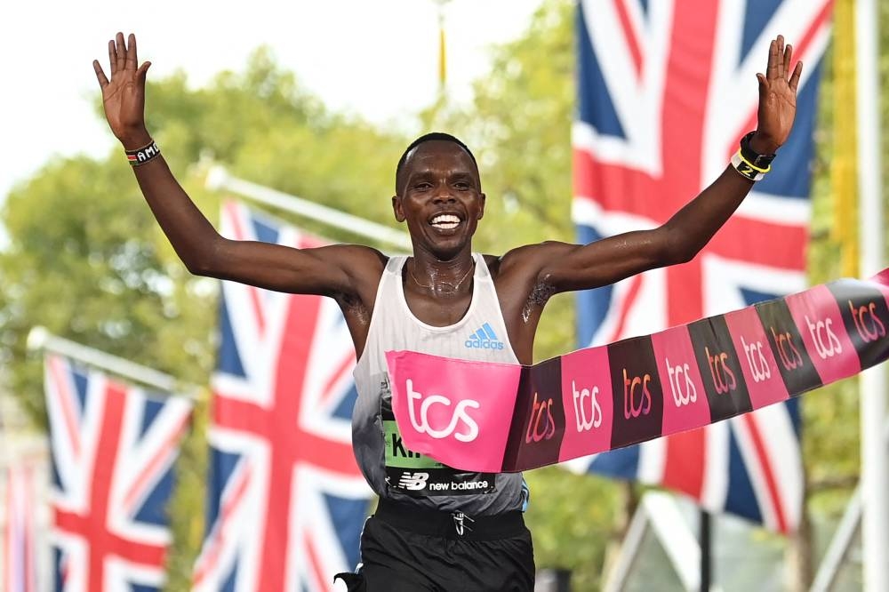 Kenya's Amos Kipruto breaks the tape to win the men's race at the finish of the 2022 London Marathon in central London on October 2, 2022. — AFP pic