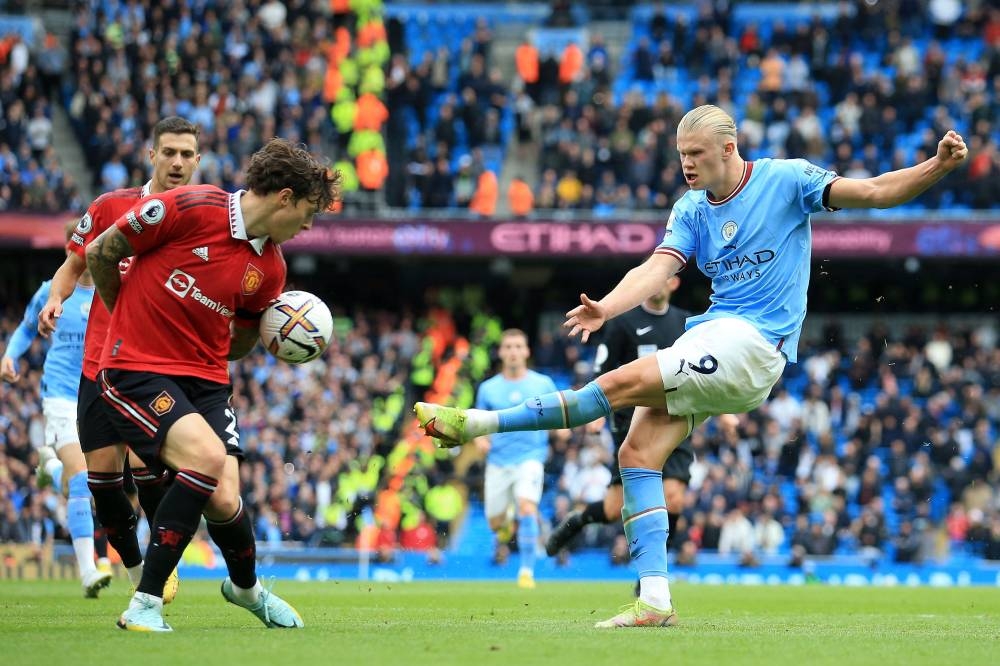 Manchester City's Norwegian striker Erling Haaland (right) shoots but fails to score during the English Premier League football match between Manchester City and Manchester United at the Etihad Stadium in Manchester, north west England, on October 2, 2022. — AFP pic