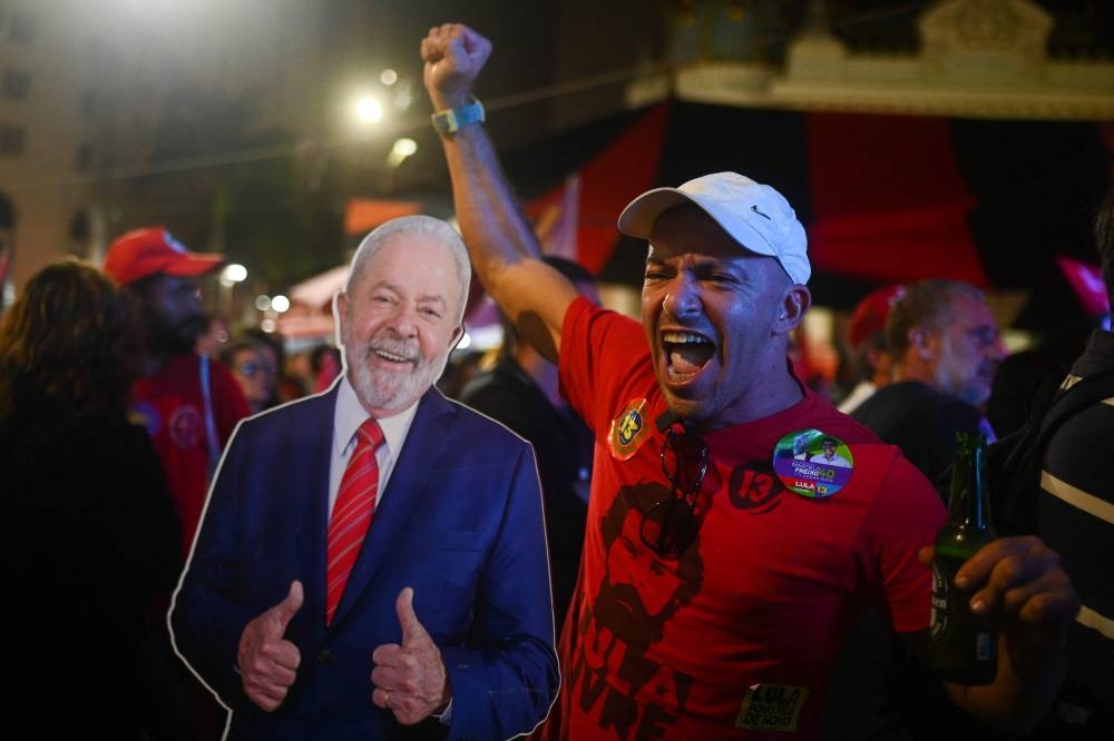 Supporters of Brazil's former President (2003-2010) and presidential candidate for the leftist Workers Party (PT) Luiz Inacio Lula da Silva react during the vote count of the legislative and presidential election, in Rio de Janeiro, Brazil, on October 2, 2022. — AFP pic