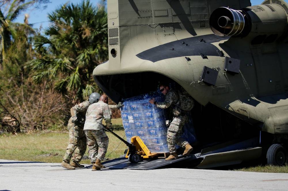 Soldiers unload water from an army helicopter near the Matlacha/Pine Island Fire Control District Station 1 after Hurricane Ian caused widespread destruction in Pine Island, Florida October 2, 2022. — Reuters pic