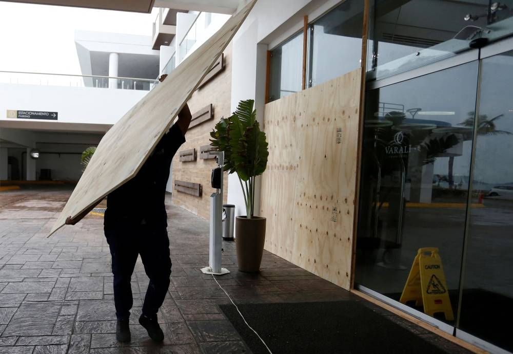 A worker boards up the windows and glass panels of a hotel on the seafront as Hurricane Orlene approaches the Pacific beach resort of Mazatlan, state of Sinaloa, Mexico October 2, 2022. — Reuters pic