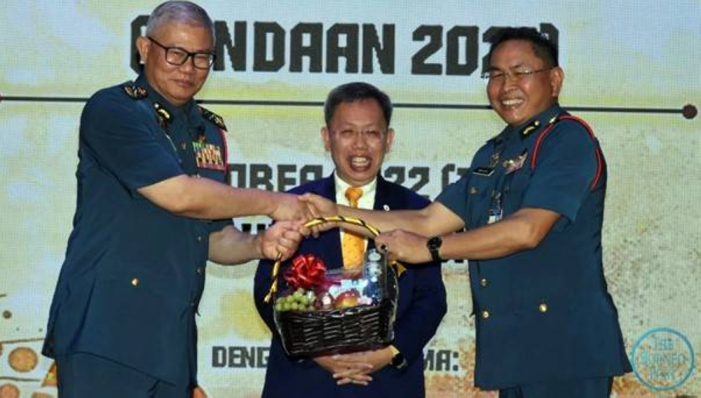 Sarawak Fire and Rescue Department director Datuk Khirudin Drahman Hussaini (right) presents a fruit hamper to Mohammad Hamdan witnessed by Datuk Seri Dr Sim Kui Hian (centre).  — Borneo Post Online pic