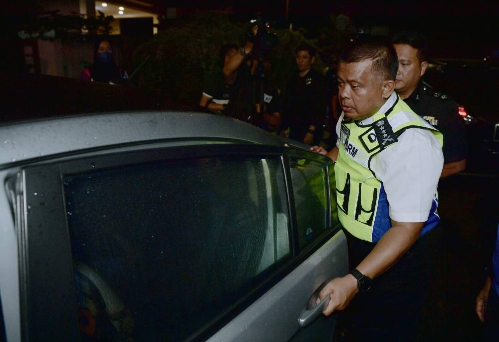 Johor Police chief Datuk Kamarul Zaman Mamat looks at a suspect who was arrested following the death of a three-year-old boy, in Johor Baru October 3, 2022. — Bernama pic