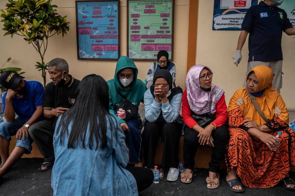 Relatives of victims wait outside a hospital in Malang, East Java October 2, 2022. — AFP pic
