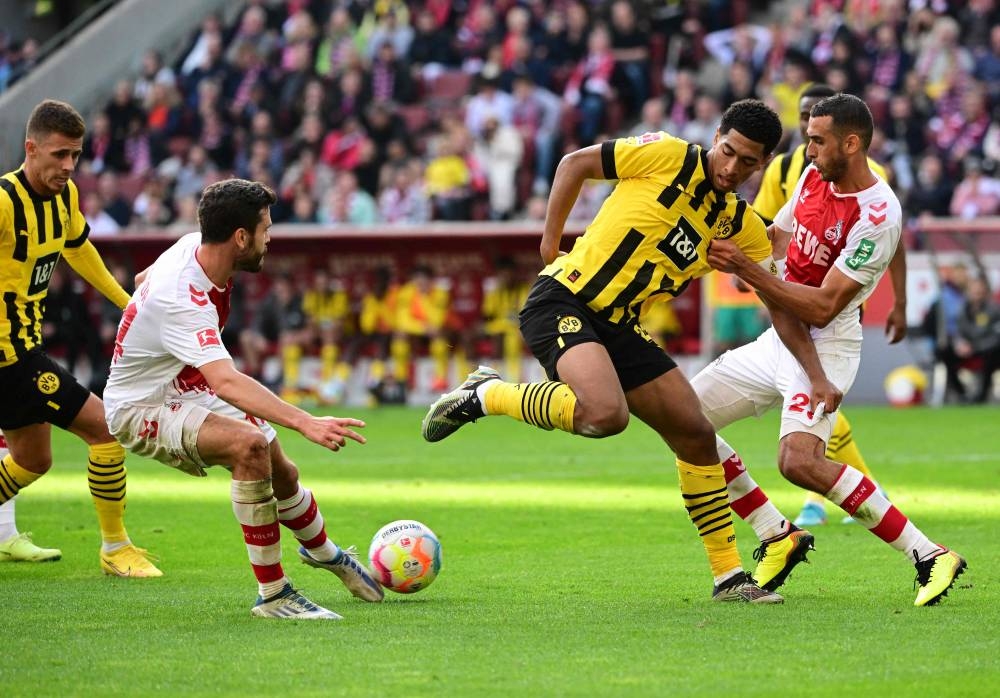 Dortmund midfielder Jude Bellingham and Cologne defender Jonas Hector vie for the ball during the German first division Bundesliga match between FC Cologne and Borussia Dortmund in Cologne, October 1, 2022. — AFP pic 