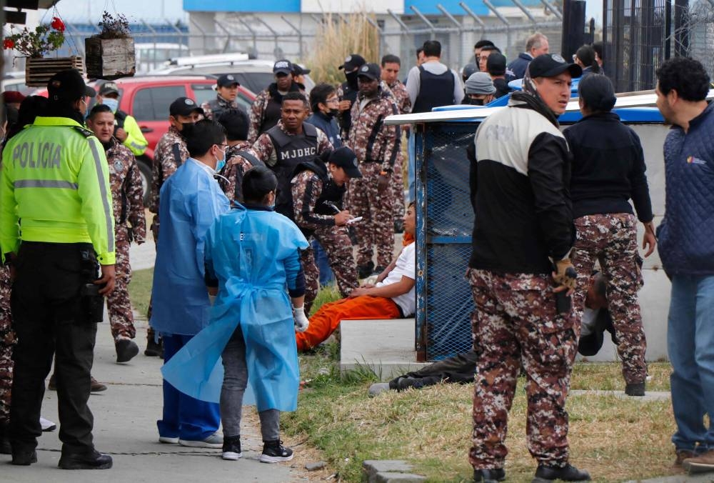 Prison guards and medical staff attend an injured prisoner (centre) following fresh clashes between inmates at the Regional Sierra Centro Norte Cotopaxi prison, in Latacunga, Ecuador October 4, 2022. — AFP pic
