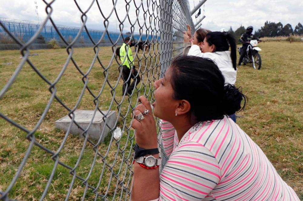 Relatives of inmates stand outside the Regional Sierra Centro Norte Cotopaxi prison as they wait for news of their loved ones after fresh clashes between prisoners were reported, in Latacunga, Ecuador October 4, 2022. — AFP pic