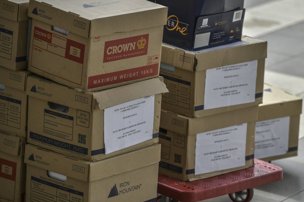 Files related to the 1Malaysia Development Berhad (1MDB) case are brought into the Kuala Lumpur Court Complexm October 5, 2022. — Picture by Hari Anggara