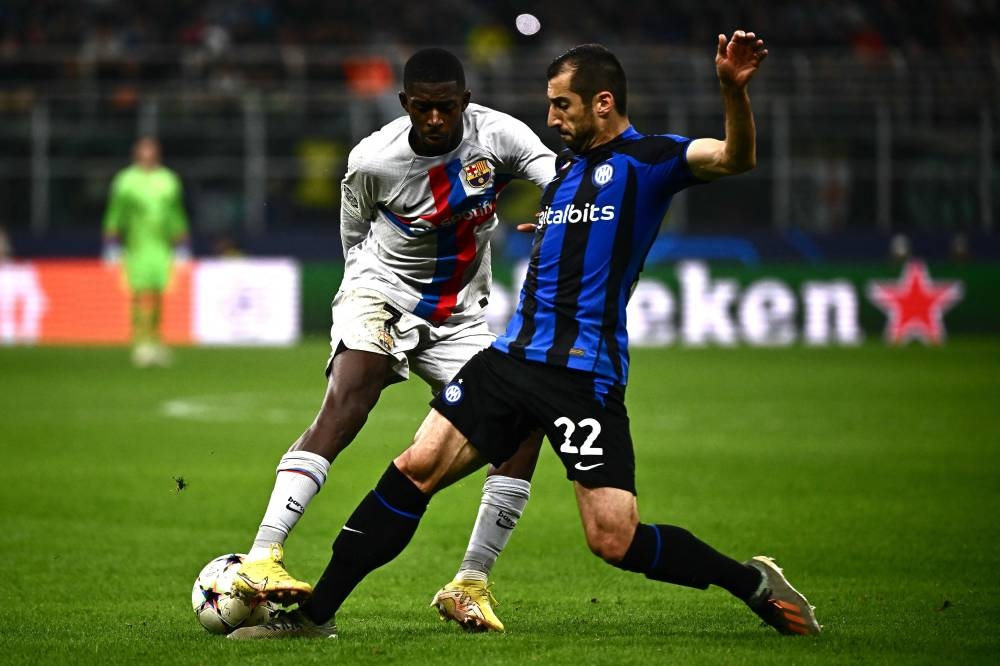 Inter Milan midfielder Henrikh Mkhitaryan tackles Barcelona forward Ousmane Dembele during the Uefa Champions League Group C match between Inter Milan and FC Barcelona on October 4, 2022 at the Giuseppe-Meazza (San Siro) stadium in Milan. — AFP pic 