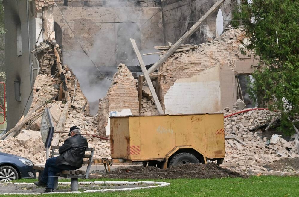 A local resident sits outside a building destroyed by Russian, Iranian-made, drones after an airstrike on Bila Tserkva, southwest of Kyiv, on October 5, 2022, amid the Russian invasion of Ukraine. — AFP pic
