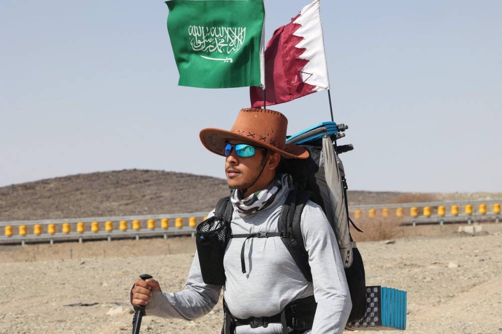 Saudi trekker Abdullah Alsulmi crosses a desert area near al-Khasrah area, some 350Km west of Riyadh, on September 27, 2022, during his solo trek to the Qatari capital ahead of the Fifa World Cup. — AFP pic