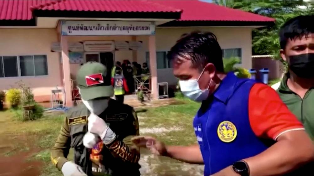 Officials and authorities guard the gate of daycare centre as people wait, after a mass shooting, in Uthai Sawan, Nong Bua Lamphu Province, Thailand in this screengrab taken from a video October 6, 2022. — TPBS/Reuters TV pic