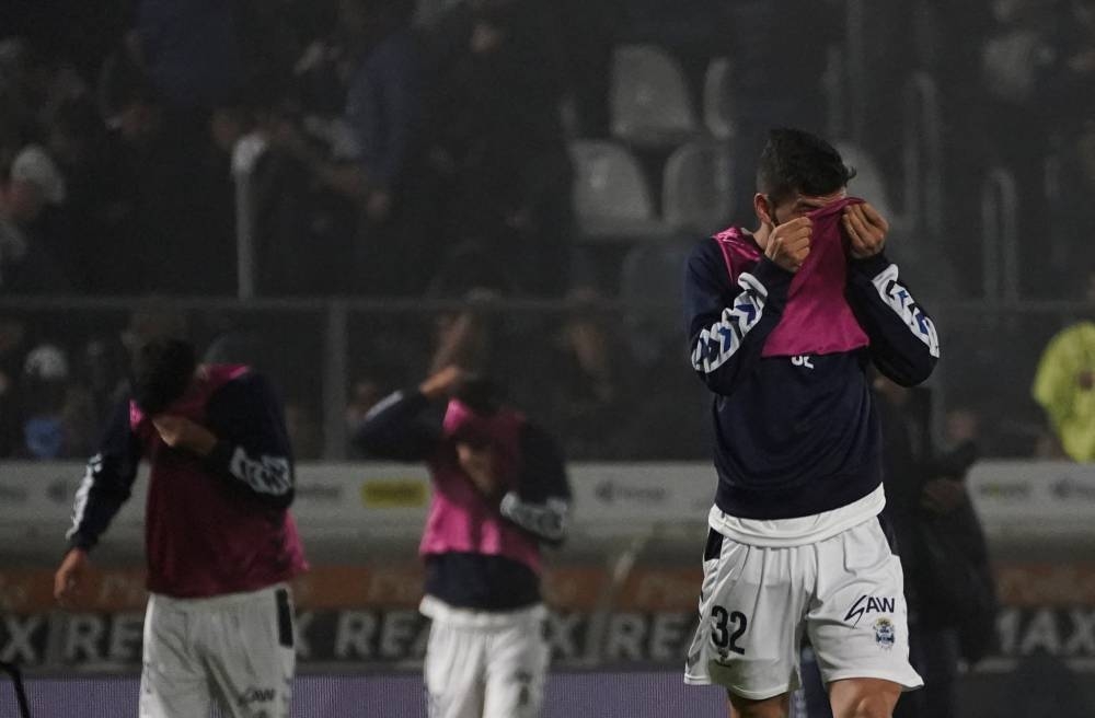 Matias Melluso, of Gimnasia y Esgrima La Plata, protects himself from tear gas during the match between Gimnasia y Esgrima La Plata and Boca Juniors in the Liga Profesional 2022, before it was suspended due clashes between supporters and the police outside the stadium, at Juan Carmelo Zerillo Stadium, in La Plata, Argentina October 6, 2022. — Reuters pic