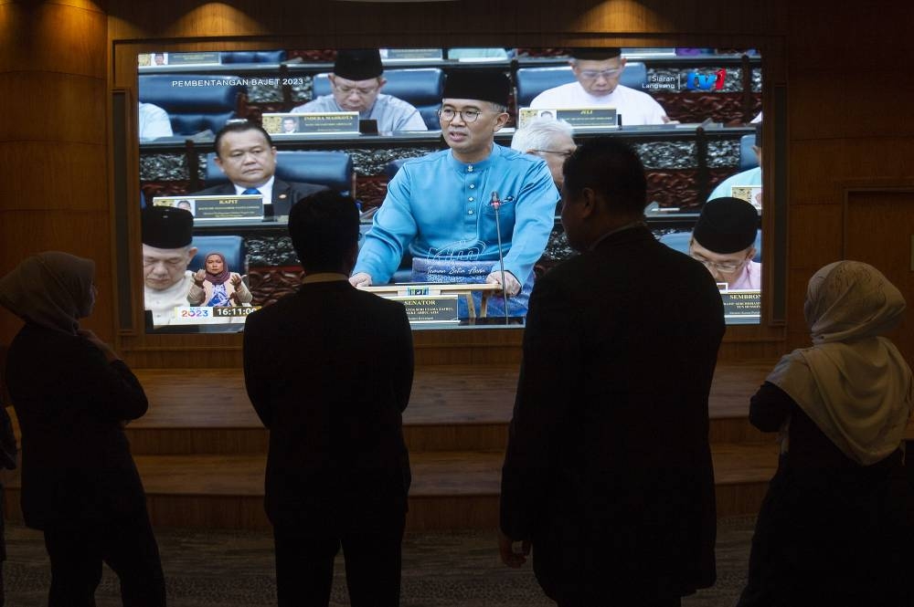 Government servants watch Finance Minister Datuk Seri Tengku Zafrul Abdul Aziz speaking during the tabling of Budget 2023 in the Dewan Rakyat, October 7, 2022. — Picture by Shafwan Zaidon