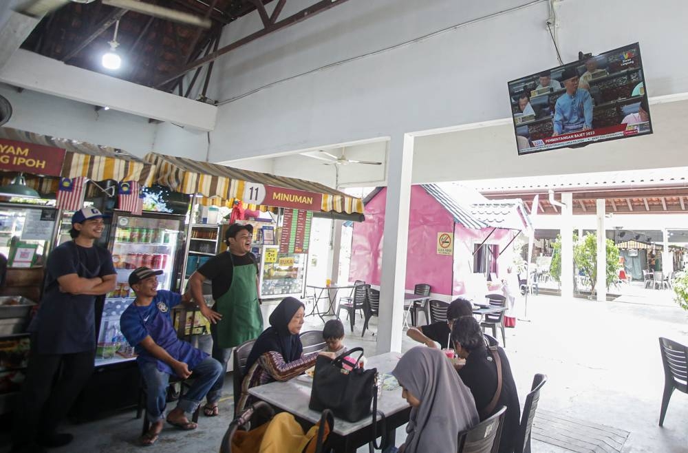 With Budget 2023 tabling under way, Ipoh people are glued to the television screens at Kompleks Silveritage to get an update of the budget being presented by Finance Minister Tengku Datuk Seri Zafrul Abdul Aziz. — Picture by Farhan Najib