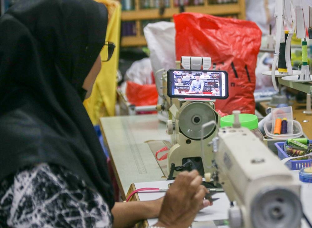 A lady in Ipoh watching Budget 2023 being presented by Finance Minister Tengku Datuk Seri Zafrul Abdul Aziz, October 7, 2022. — Picture by Farhan Najib