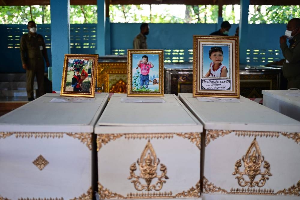 Portraits of child victims are displayed at the top of their coffins for the funeral rituals at the Wai Si Uthai temple in Na Klang in Thailand's northeastern Nong Bua Lam Phu province on October 7, 2022. - Weeping, grief-stricken families gathered on October 7 outside a Thai nursery where an ex-policeman murdered two dozen children in one of the kingdom's worst mass killings. — AFP pic