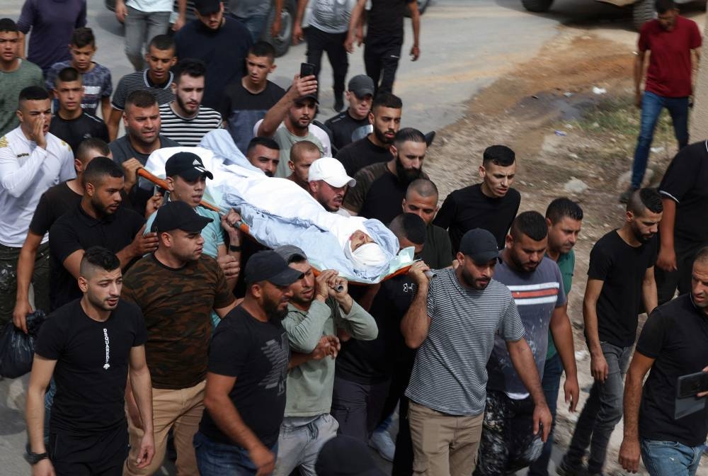 Palestinian mourners carry the body of Ahmad Daraghmeh who was killed by Israeli forces in Jenin city in the occupied West Bank, on October 8, 2022. — AFP pic