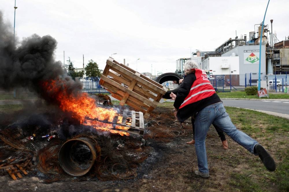 Workers on strike burn a fire in front of the ExxonMobil oil refinery in Port-Jerome-sur-Seine, France, October 5, 2022. — Reuters pic